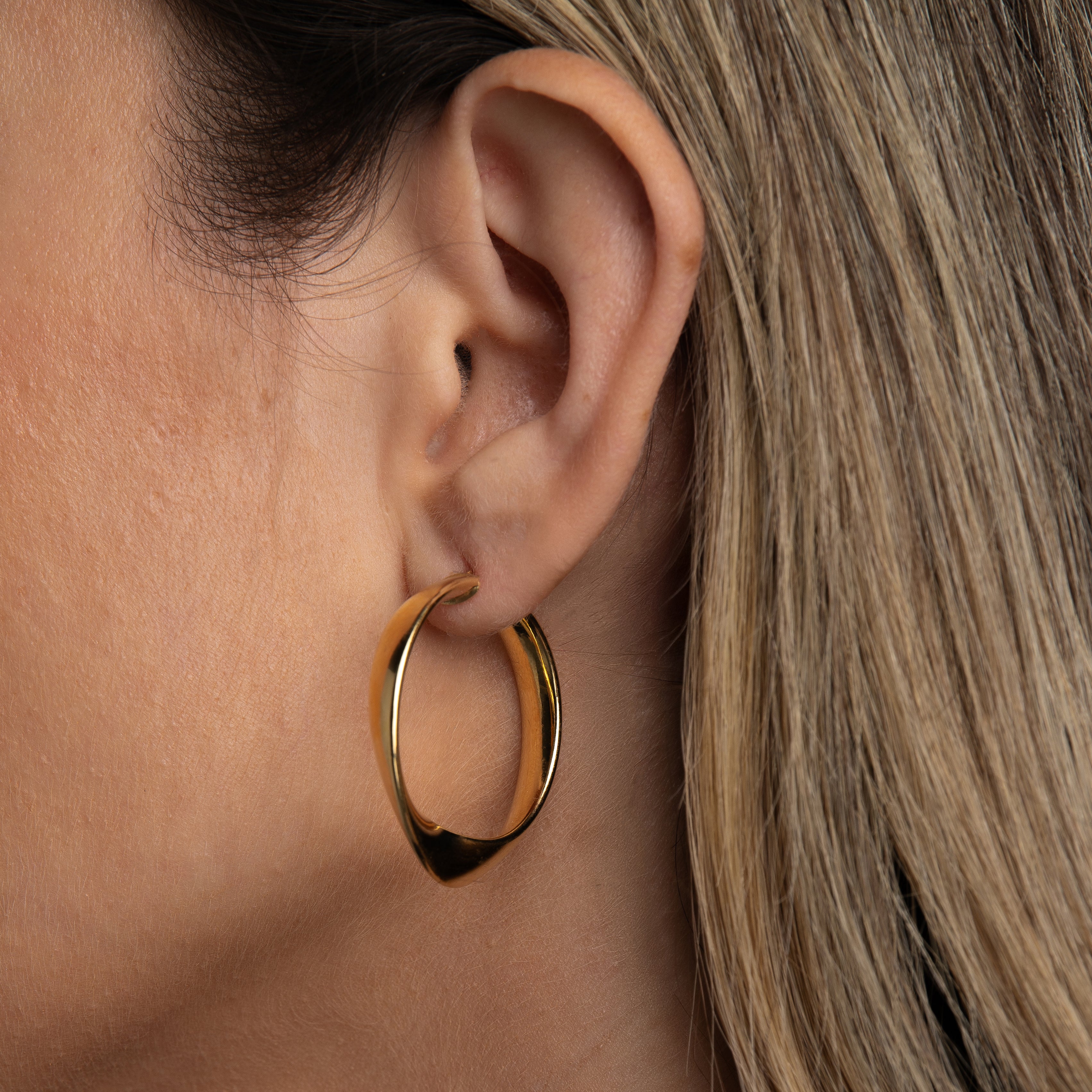 twisted oval hoop earrings worn by model